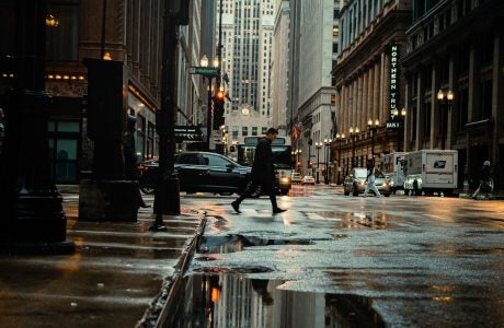 New York City street with pedestrian walking and cars driving by