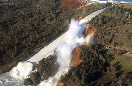 aerial view of water overflow on damaged dam