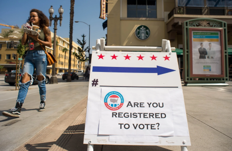 Sign with text "Are you registered to vote?" on sidewalk