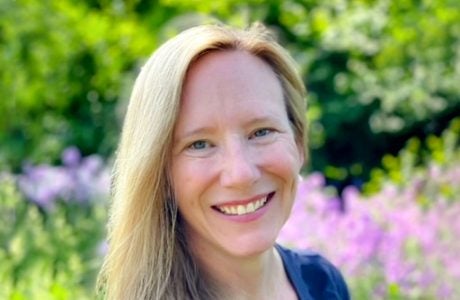 photo of woman with blond hair in front of flowering plants