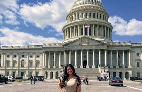 Young woman stands in front of the U.S. Capitol.
