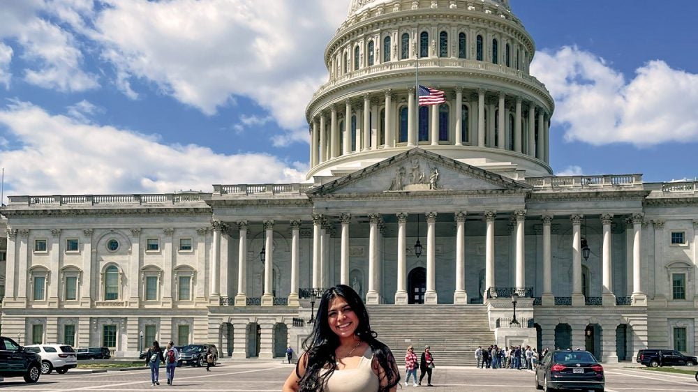 Young woman stands in front of the U.S. Capitol.