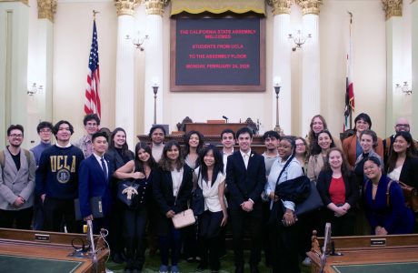 Group of young people in ornate legislative chamber||