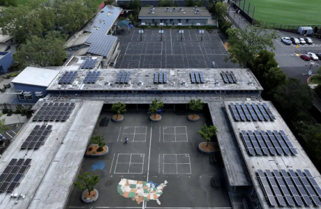 Aerial view of school campus with solar panels on roofs.