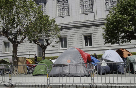 Tents at a homeless encampment in front of a building