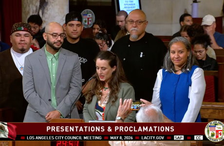 Los Angeles City Council Meeting on May 8, a speaker presents José Loya and Amada Armenta with their "impactful chicanos" award at City Hall.|Two photos next to each other, on the left is Jose Loya and Amada Armenta holding up their "Impactful Chicanos" awards inside City Hall, the photo on the right is of Jose and Amada standing next to a framed illustration of UCLA Latino Policy and Politics Institute.