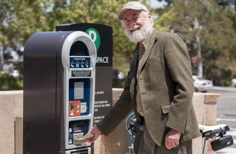 Man at parking kiosk|Man in sweater in front of bookcase
