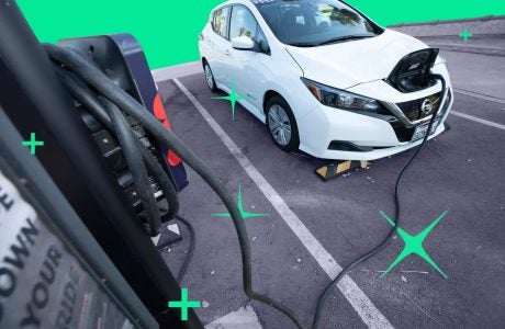 Electric car parked in a parking lot that is plugged in to a charging port