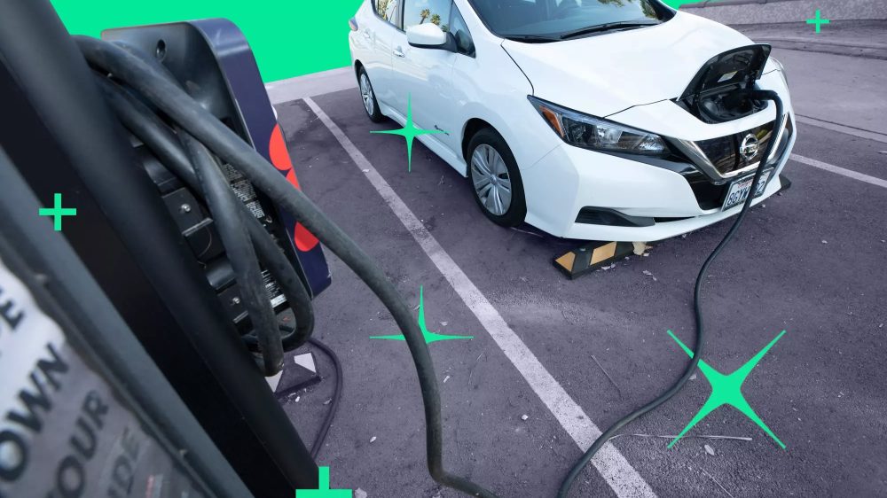 Electric car parked in a parking lot that is plugged in to a charging port