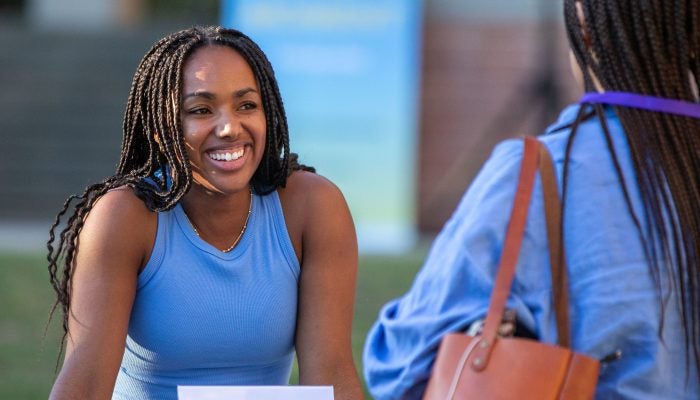Student smiles at another student while in conversation