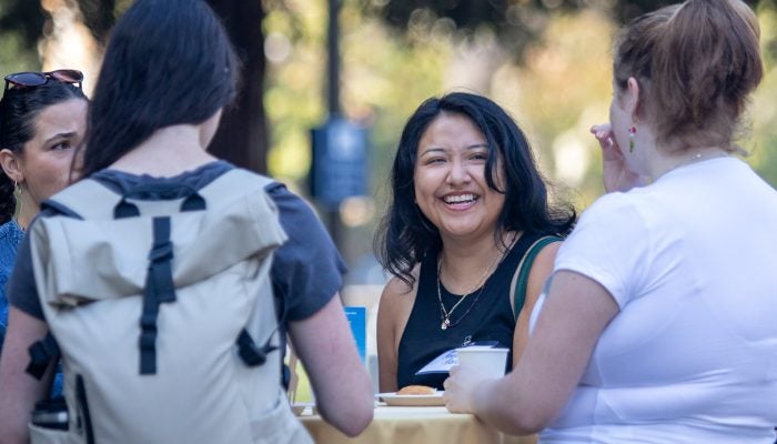 Student smiles at classmates during Luskin Graduate Student Orientation 2025.