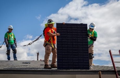 Man teaches students to install roof solar panel