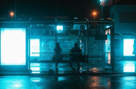 two people at bus stop at night