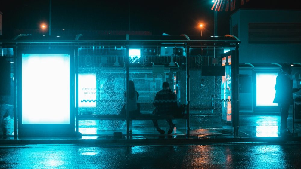 two people at bus stop at night