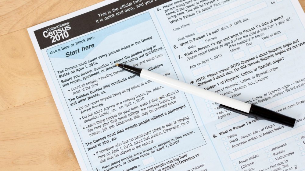 US, Census form document with pen on top|Family walking together.