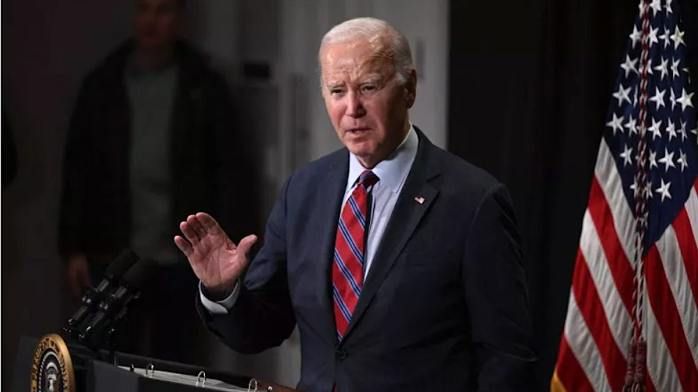 Man in suit and tie at podium next to American flag