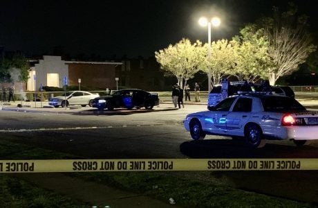 Police cars are parked behind yellow caution tape in front of a church in Alabama.