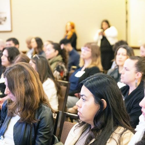 Attendees seated and listening to a presented at an academic event