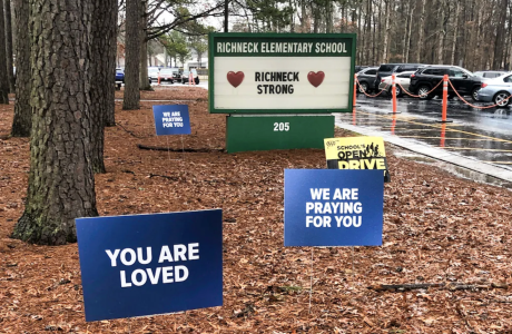 front of elementary school with signs expressing encouragement