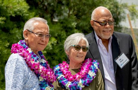 three people outdoors, two wearing leis|three young people in historic B&W photo