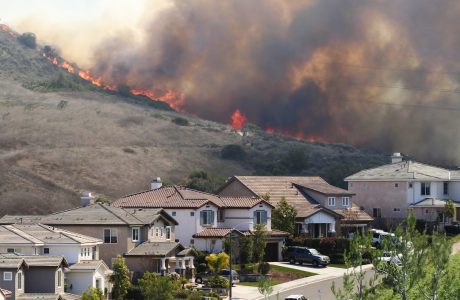Flames on ridge in back of street with two-story houses