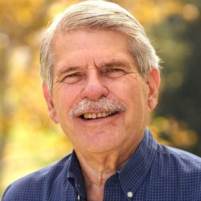 Man with moustache smiling outdoors