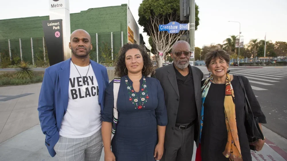 four people stand outside a Metro stop in Los Angeles