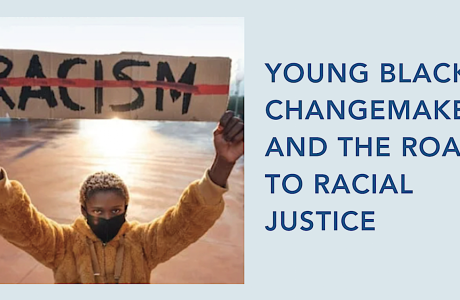 young person holding sign with word 'racism' marked out