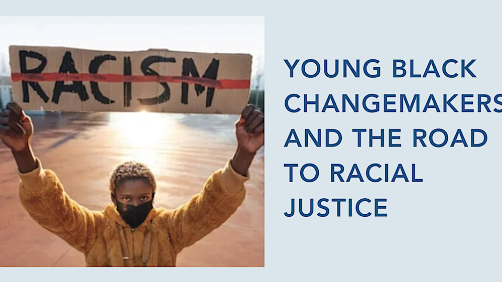 young person holding sign with word 'racism' marked out