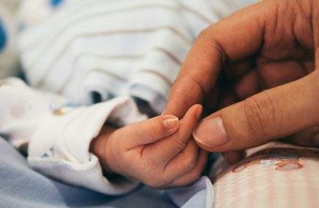 infant hand held by adult hand