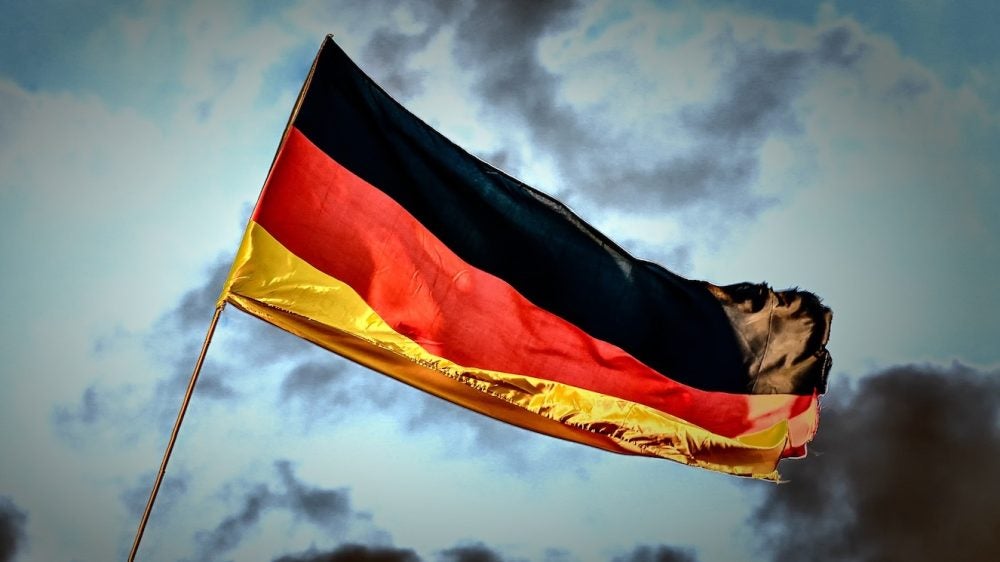 flag with black, red, yellow stripes against stormy sky