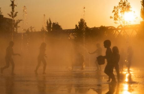 childen play amid fountains on a sunny day