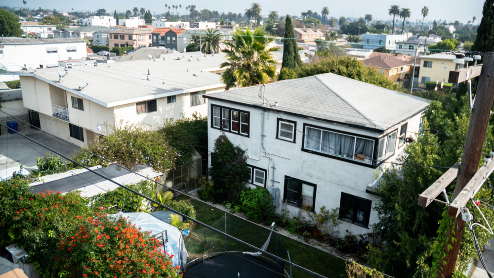 An aerial shot of a Los Angeles neighborhood, photo of a white apartment building.
