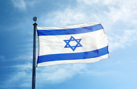 Israel flag with a blue sky in the background.