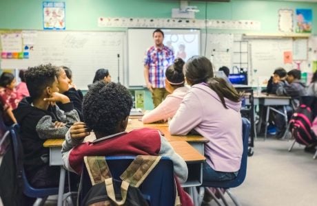 Classroom scene with teacher standing and students sitting