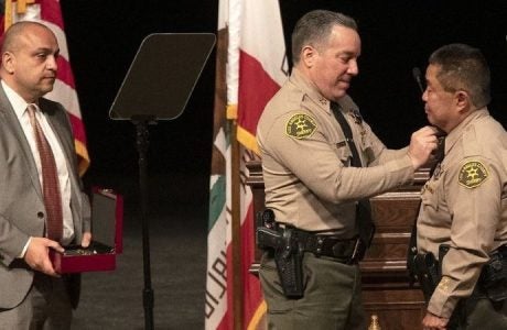 Deputy Caren Carl Mandoyan, left, shown with Sheriff Alex Villanueva, center.