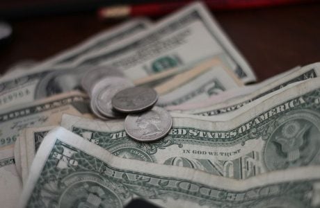 A few coins on top of several one dollar bills