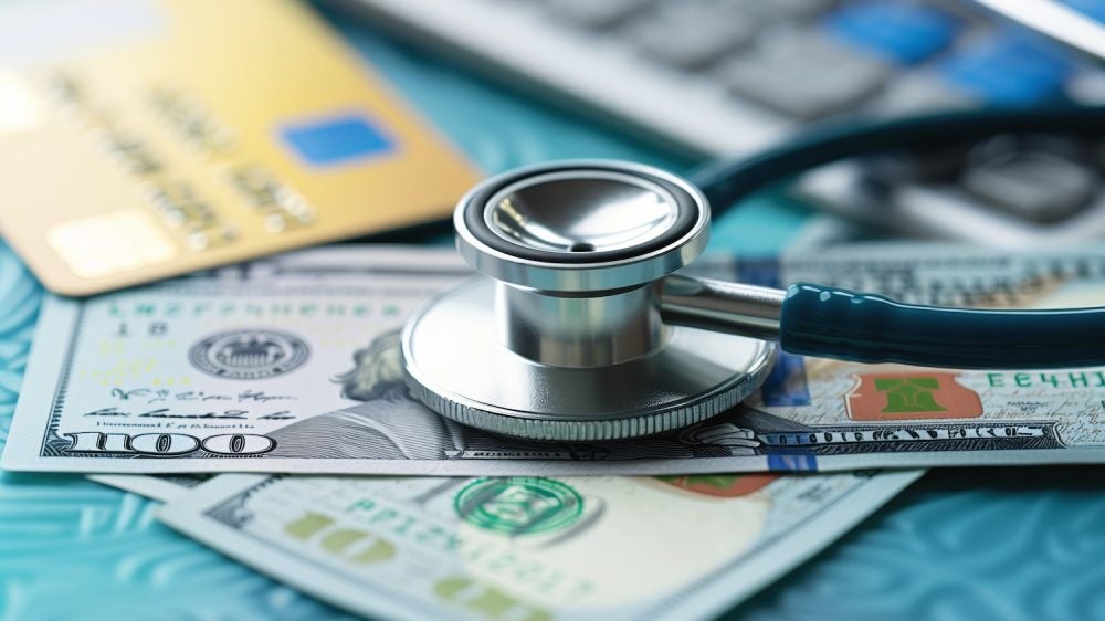 Stethoscope on money and credit cards, symbolizing medical costs