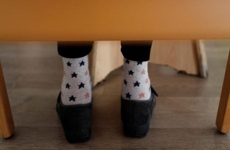 file image of a person's feet under a chair