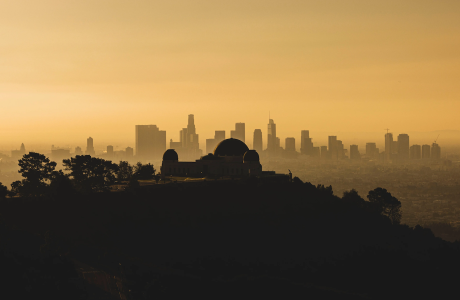 silhouette of Griffith Observatory set again orange sky and Los Angeles skyline